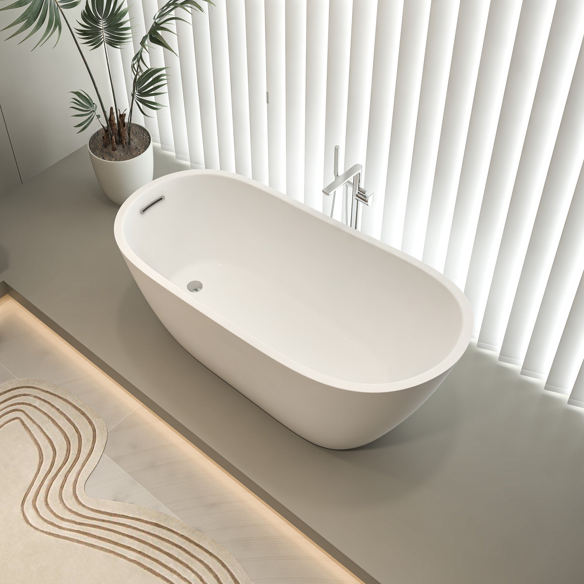 Modern white freestanding bathtub in a stylish bathroom with natural lighting and minimalist decor.